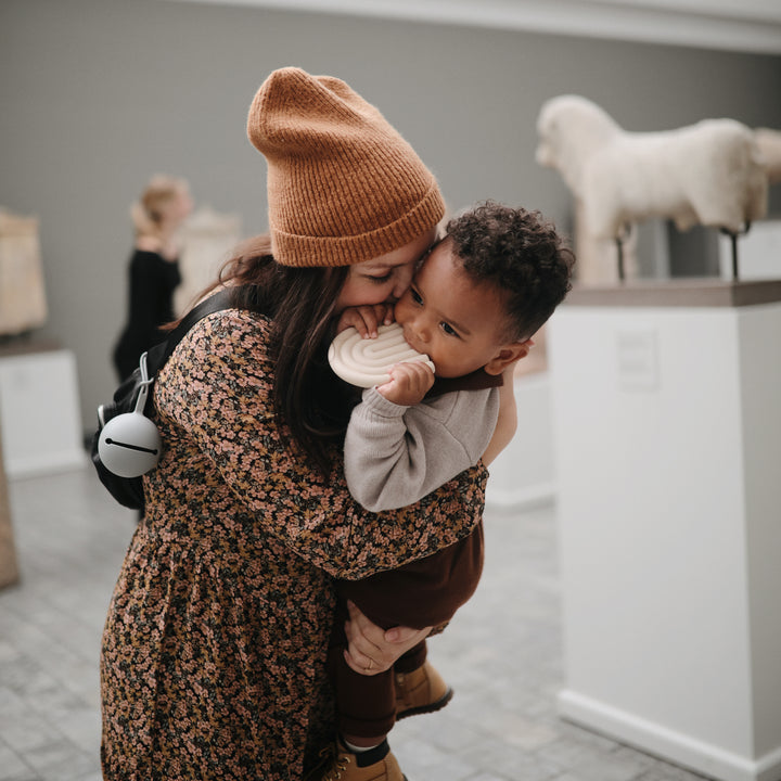 Schnullerhalter von Mushie in grau - Einfach an Wickeltasche oder Kinderwagen befestigen und Schnuller immer griffbereit haben. 