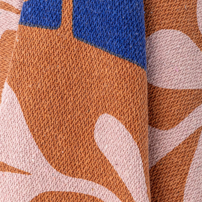 Decke "Alte" in Braun-und Rosétönen von Bloomingville: Mit floralen Muster und Fransen. 