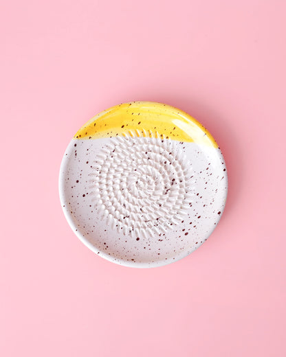 Kleine, handgefertige Keramikreibe mit schwarzen Klecksen und gelbem Highlight - Ideal zum Reiben von Knoblauch, Ingwer oder Schokolade. 