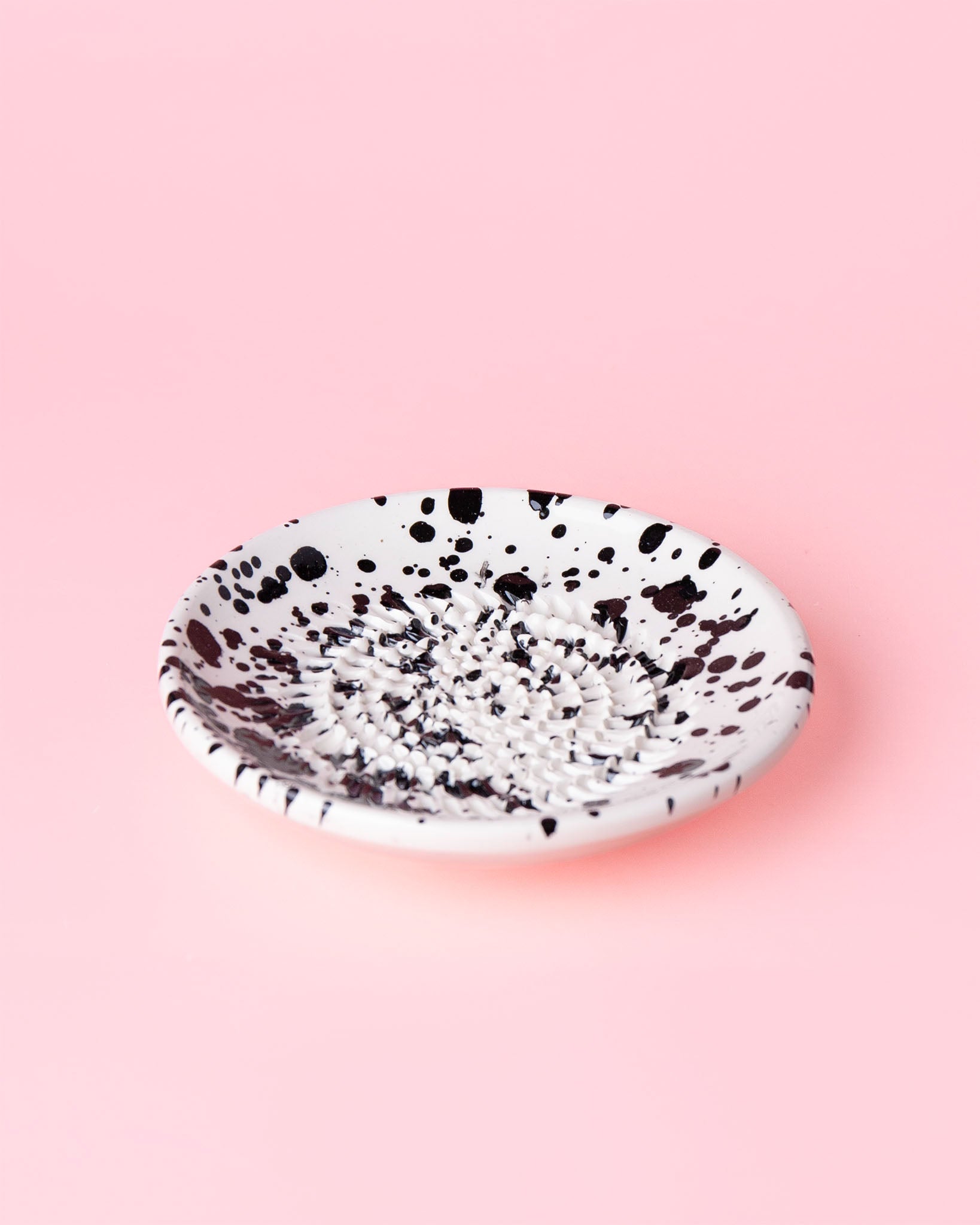 Kleine, handgefertige Keramikreibe mit schwarzen Klecksen - Praktisch, dekorativ und eine schöne Geschenkidee für Feinschmecker.