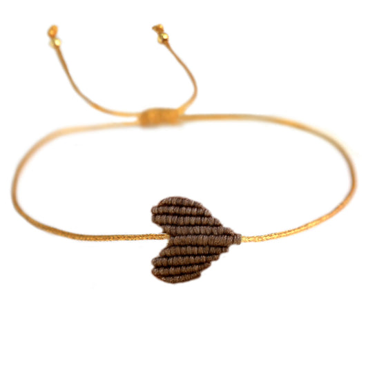 Armband mit goldenem Band und geflochtenem Herz in braun von Love Ibiza. Dank praktischem Schiebeknoten passt das Armband an jedes Handgelenk! 
