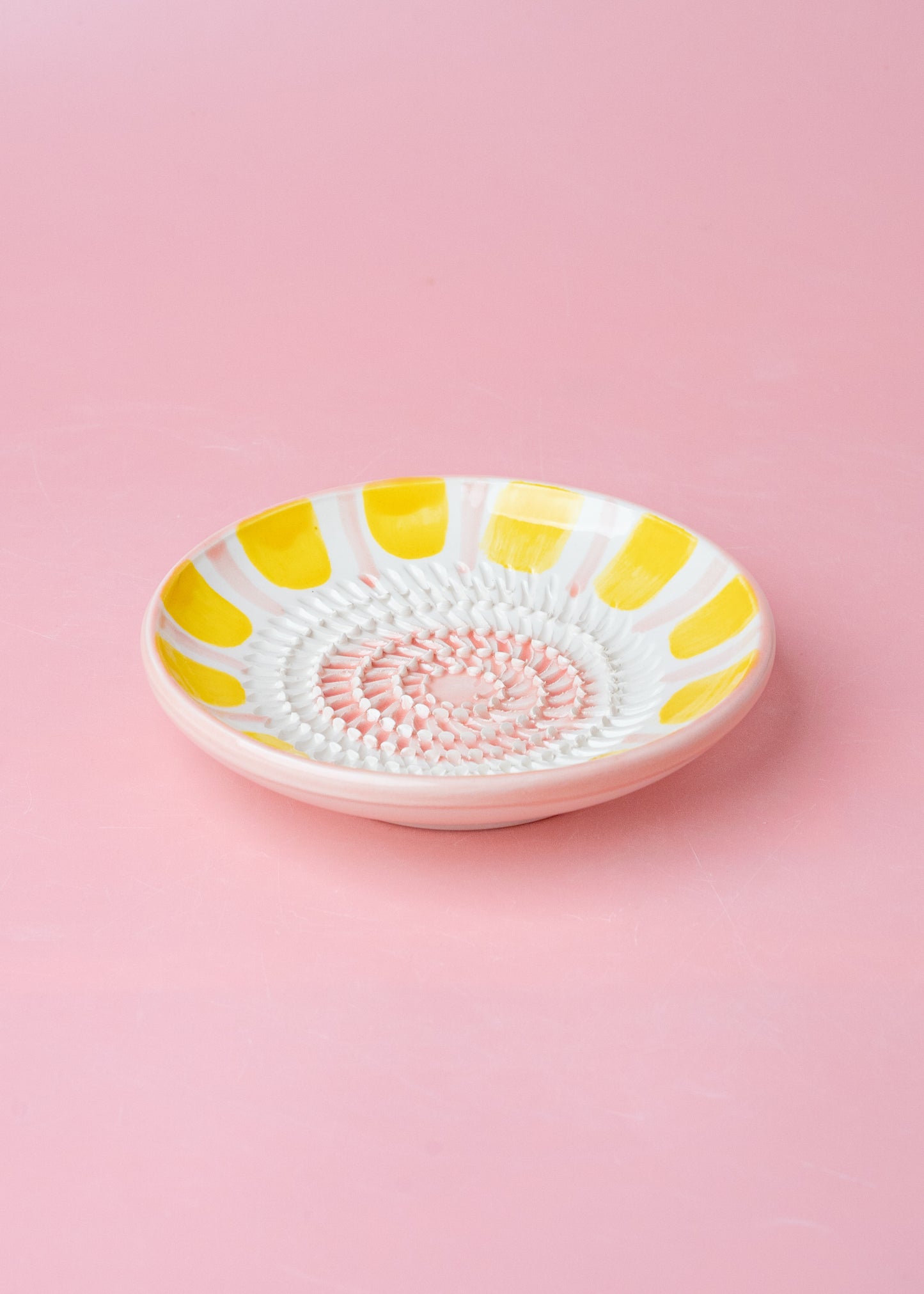 Kleine, handgefertige Keramikreibe mit gelb rosa Dekor - Praktisch, dekorativ und eine schöne Geschenkidee für Feinschmecker.