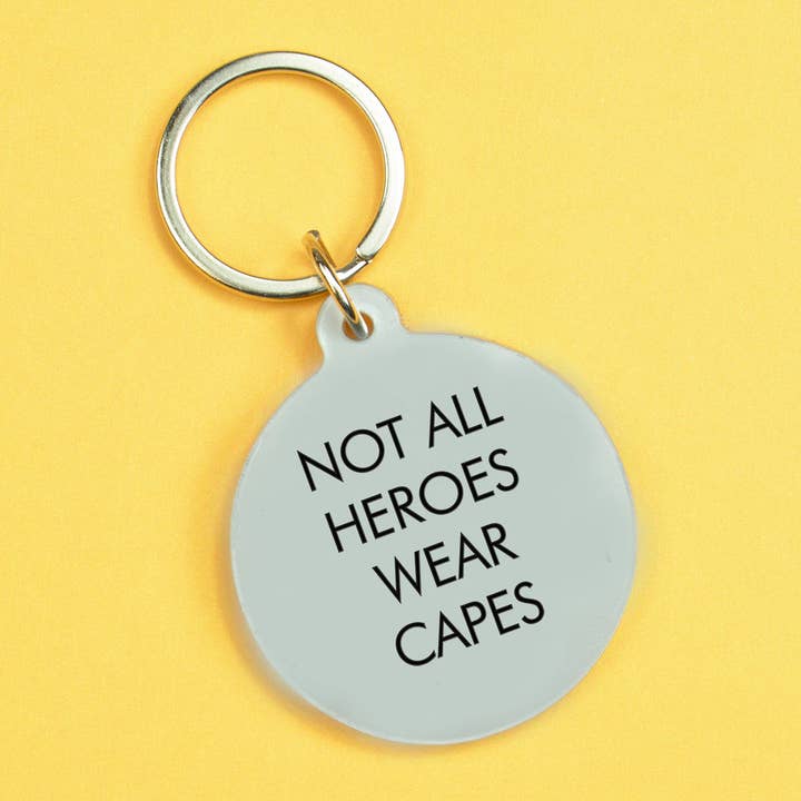 Schlüsselanhänger von Flamingo Candles mit Statement "Not all heros wear capes" auf grauem Acryl graviert. 