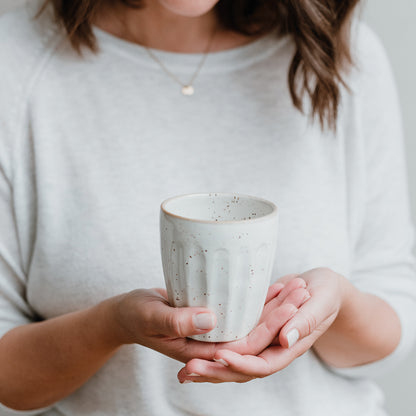 Becher Colina von Eulenschnitt – in der Hand gehalten, stilvoller Steingutbecher
