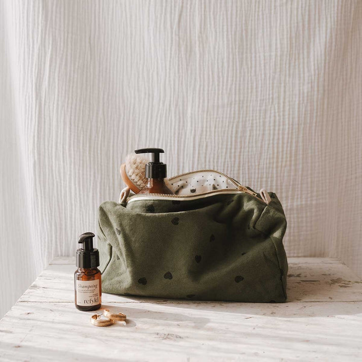 Kosmetikbeutel "Vic" von Rose in April in moosgrün mit schwarzen Herzen: Ideal für einen Wochenendtrip oder Urlaub